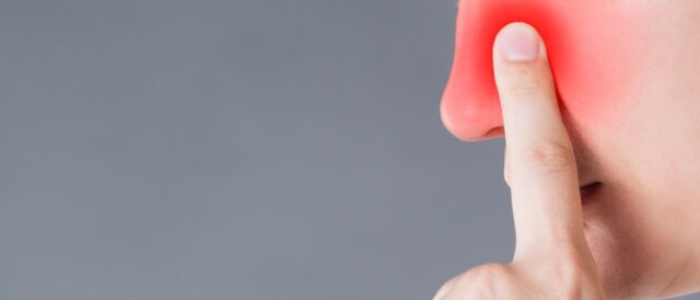 a person point his reddish nose