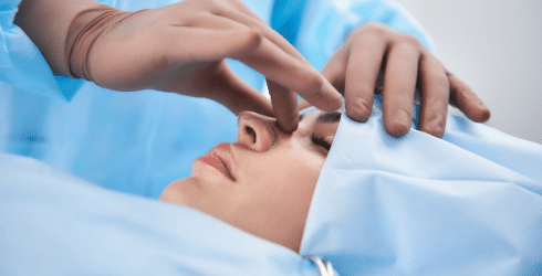 doctor holding patient nose in surgery room